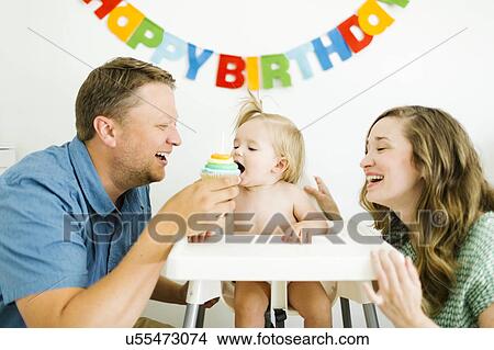 Mother and father celebrating first birthday of daughter (12-17 months) View Large Photo Image Picture - Mother and father celebrating first birthday of daughter (12-17 months). Fotosearch