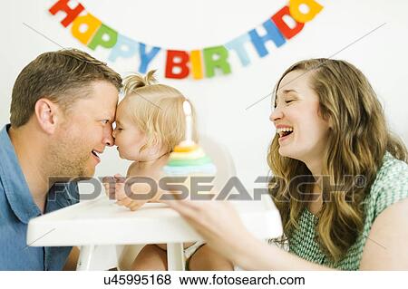Stock Photo - Mother and father celebrating first birthday of daughter (12-17 months). Fotosearch
