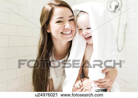 Stock Image - Mother and son (4-5) laughing in bathroom. Fotosearch
