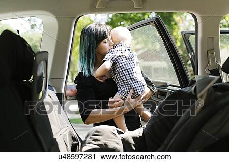 Mother carrying baby boy ( 12-17 months ) into car View Large Photo Image Stock Image - Mother carrying baby boy ( 12-17 months ) into car. Fotosearch