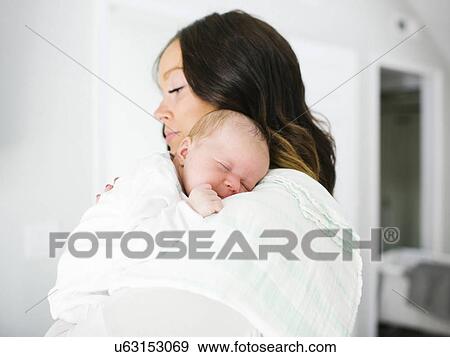 Stock Photo - Mother carrying daughter (0-1 months). Fotosearch