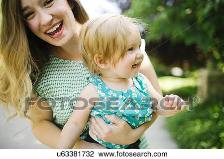 Mother carrying daughter (12-17 months) View Large Photo Image Stock Image - Mother carrying daughter (12-17 months). Fotosearch