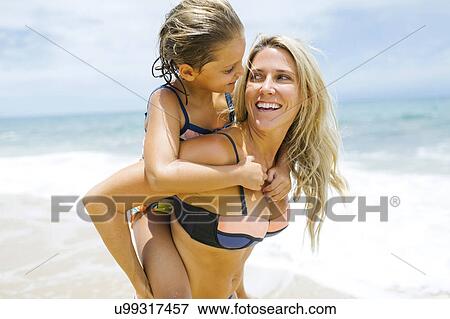 Mother carrying daughter (6-7) on back View Large Photo Image Stock Photo - Mother carrying daughter (6-7) on back. Fotosearch