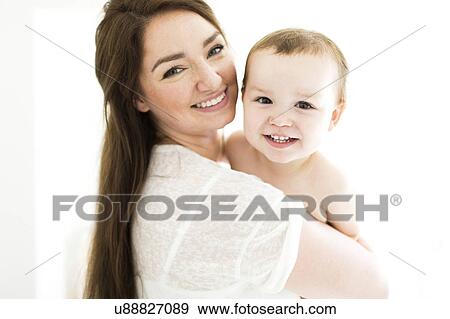Mother carrying son (4-5) and smiling View Large Photo Image Stock Photo - Mother carrying son (4-5) and smiling. Fotosearch
