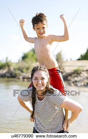 Mother carrying son (6-7) on back View Large Photo Image Stock Image - Mother carrying son (6-7) on back. Fotosearch
