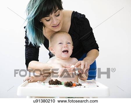 Mother cleaning baby boy (12-17 months) from cupcake View Large Photo Image Stock Image - Mother cleaning baby boy (12-17 months) from cupcake. Fotosearch