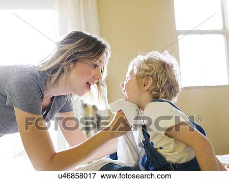 Stock Photo - Mother cleaning son's face (4-5) with towel. Fotosearch