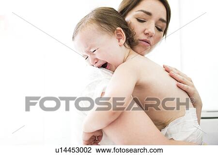 Stock Image - Mother embracing and consoling son (4-5). Fotosearch