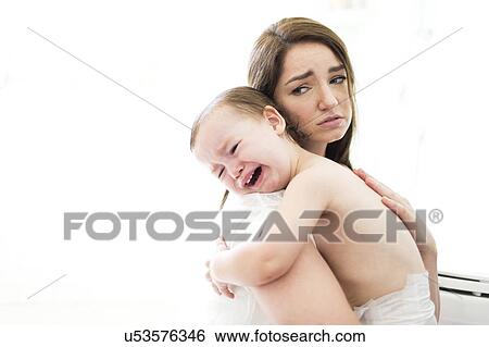 Stock Photograph - Mother embracing and consoling son (4-5). Fotosearch