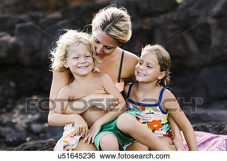 Stock Photograph - Mother embracing kids (4-5, 6-7). Fotosearch