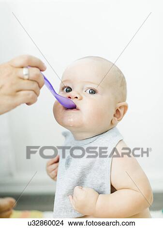 Mother feeding son (6-11 months) View Large Photo Image Picture - Mother feeding son (6-11 months). Fotosearch