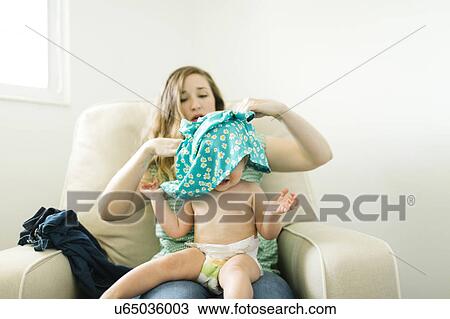 Mother getting dressed daughter (11-17 months) in living room View Large Photo Image Stock Image - Mother getting dressed daughter (11-17 months) in living room. Fotosearch