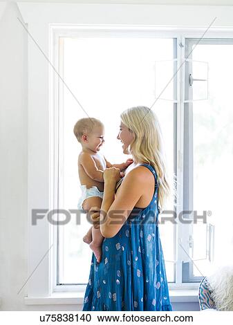 Stock Image - Mother holding baby boy (18-23 months). Fotosearch
