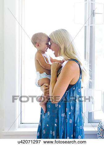 Stock Photo - Mother holding baby boy (18-23 months). Fotosearch