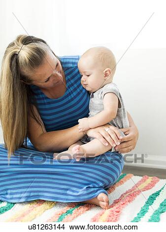 Picture - Mother holding her son (6-11 months) on lap. Fotosearch