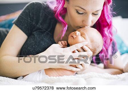 Stock Photo - Mother holding newborn son (2-5 months). Fotosearch