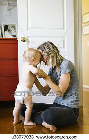 Stock Image - Mother holding son (12-17 months). Fotosearch