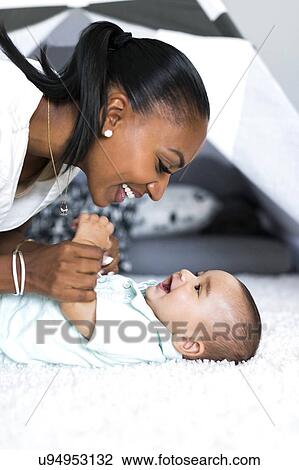 Stock Image - Mother looking at baby boy (2-5 months). Fotosearch