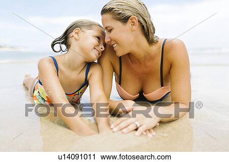 Mother lying with daughter (6-7) on beach View Large Photo Image Stock Image - Mother lying with daughter (6-7) on beach. Fotosearch