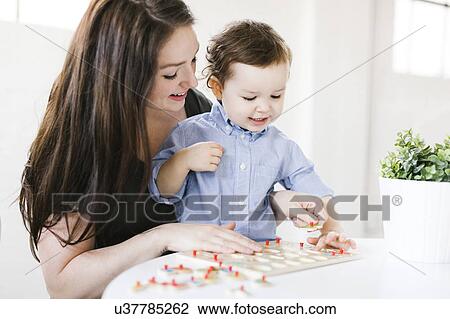 Stock Image - Mother playing alphabet game with son (4-5). Fotosearch