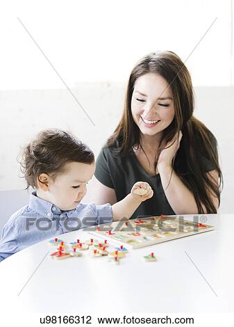Stock Image - Mother playing alphabet game with son (4-5). Fotosearch
