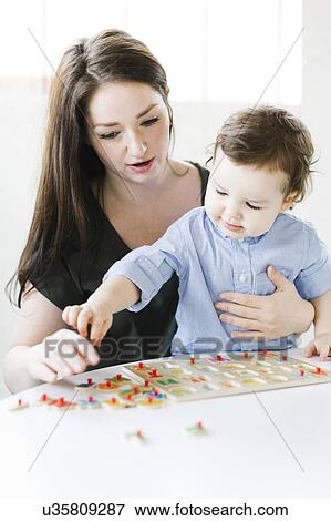 Stock Photo - Mother playing alphabet game with son (4-5). Fotosearch