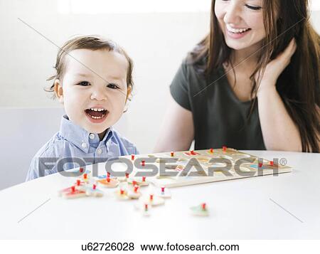 Stock Photo - Mother playing alphabet game with son (4-5). Fotosearch