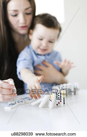 Stock Photo - Mother playing domino game with son (4-5). Fotosearch