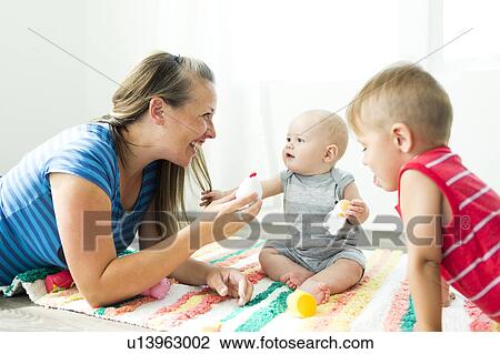 Mother playing with her two children (6-11 months, 2-3) View Large Photo Image Stock Image - Mother playing with her two children (6-11 months, 2-3). Fotosearch