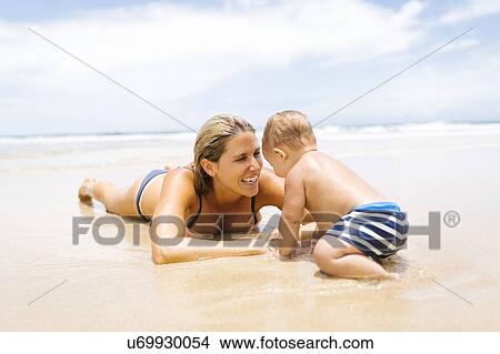 Picture - Mother playing with son (12-17 months) on beach. Fotosearch