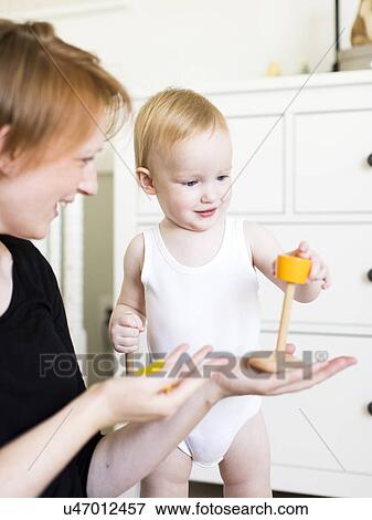 Mother playing with son (12-17 months) in nursery View Large Photo Image Stock Photo - Mother playing with son (12-17 months) in nursery. Fotosearch
