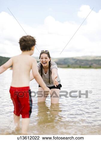 Mother playing with son (4-5) in lake View Large Photo Image Stock Image - Mother playing with son (4-5) in lake. Fotosearch