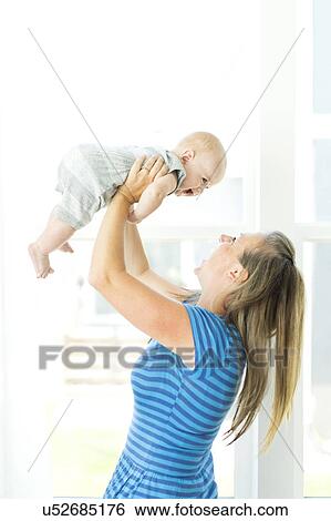 Stock Photograph - Mother playing with son (6-11 months). Fotosearch