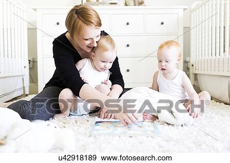 Mother playing with sons (12-17 months) in nursery View Large Photo Image Stock Photo - Mother playing with sons (12-17 months) in nursery. Fotosearch