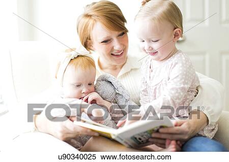 Mother reading book to daughters ( 12-17 months ) View Large Photo Image Stock Photography - Mother reading book to daughters ( 12-17 months ). Fotosearch