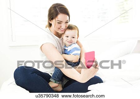 Mother taking selfie with son (4-5) View Large Photo Image Stock Photo - Mother taking selfie with son (4-5). Fotosearch