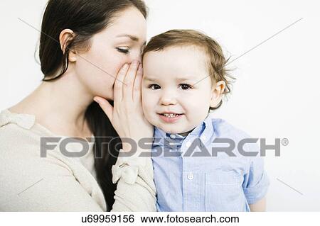 Mother whispering into son's (4-5) ear View Large Photo Image Stock Photograph - Mother whispering into son's (4-5) ear. Fotosearch