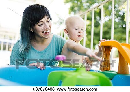 Mother with baby boy (12-17 months) playing with inflatable toys View Large Photo Image Stock Photo - Mother with baby boy (12-17 months) playing with inflatable toys. Fotosearch