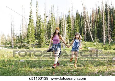 Stock Photo - Mother with daughter (8-9) hiking in forest. Fotosearch