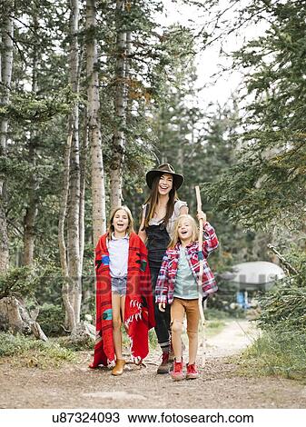 Stock Image - Mother with son (6-7) and daughter (8-9) hiking in forest. Fotosearch