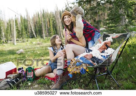 Stock Photo - Mother with son (6-7) and daughter (8-9) camping in forest. Fotosearch