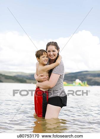 Mother with son (6-7) embracing while wading in lake View Large Photo Image Stock Image - Mother with son (6-7) embracing while wading in lake. Fotosearch