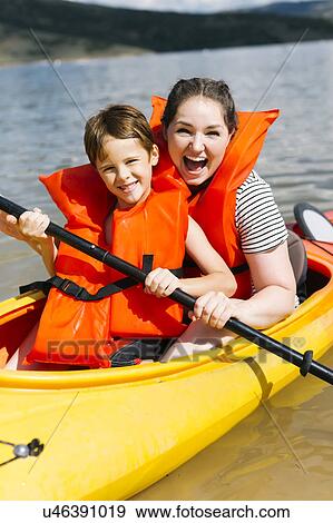 Stock Photo - Mother with son (6-7) kayaking on lake. Fotosearch
