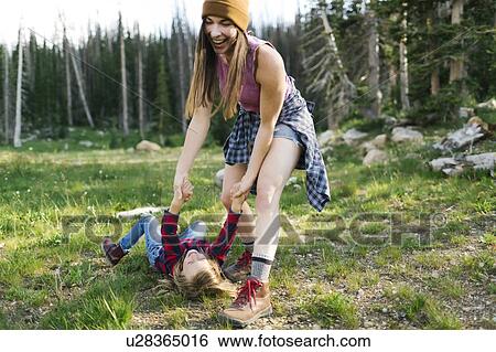 Stock Photograph - Mother with son (6-7) rough housing in forest. Fotosearch