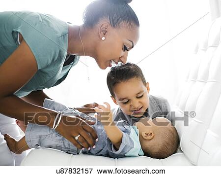 Mother with two sons (2-5 months, 2-3) on sofa View Large Photo Image Stock Photo - Mother with two sons (2-5 months, 2-3) on sofa. Fotosearch