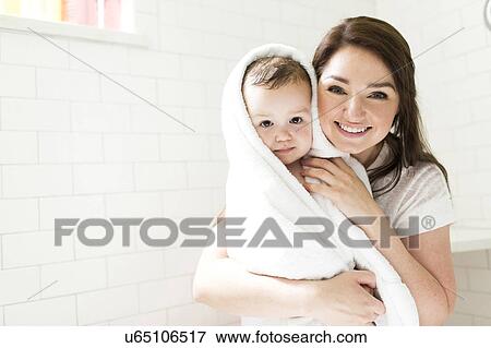 Mother wrapping son (4-5) in towel in bathroom View Large Photo Image Stock Photo - Mother wrapping son (4-5) in towel in bathroom. Fotosearch