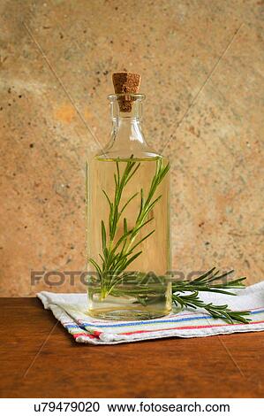 Stock Image - Olive oil bottle with rosemary leaves. Fotosearch