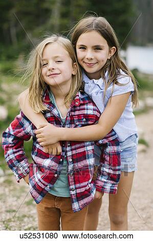 Stock Image - Outdoor portrait of brother (6-7) and sister ( 8-9) in forest. Fotosearch