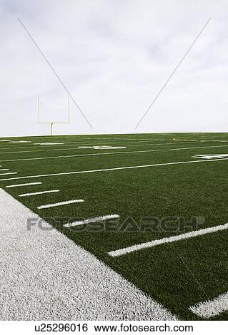 Stock Photograph - Overcast sky above american football field and goal post. Fotosearch