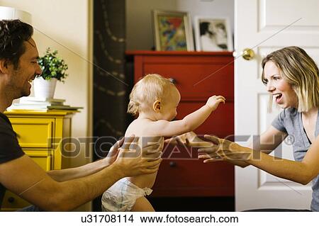Parents assisting in son's (12-17 months) first step View Large Photo Image Picture - Parents assisting in son's (12-17 months) first step. Fotosearch